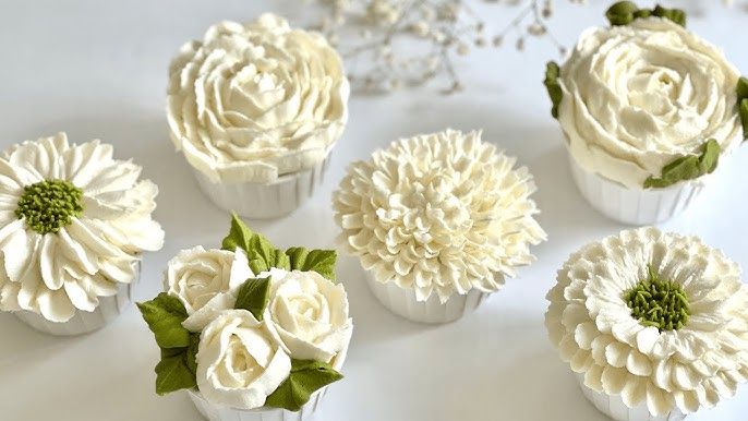 Sex eleganta cupcakes dekorerade som vita blommor för bröllop.