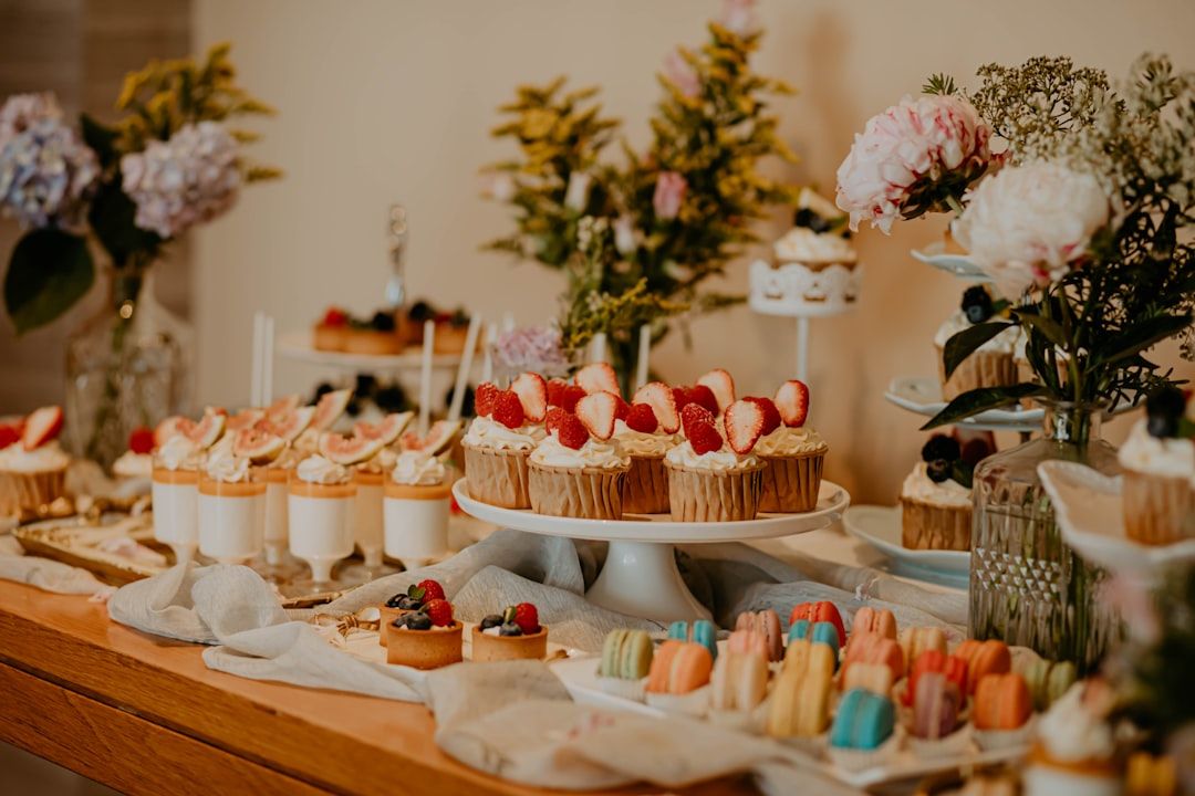 Ett vackert dukat efterrättsbord med cupcakes, macarons och minidesserter till fest.